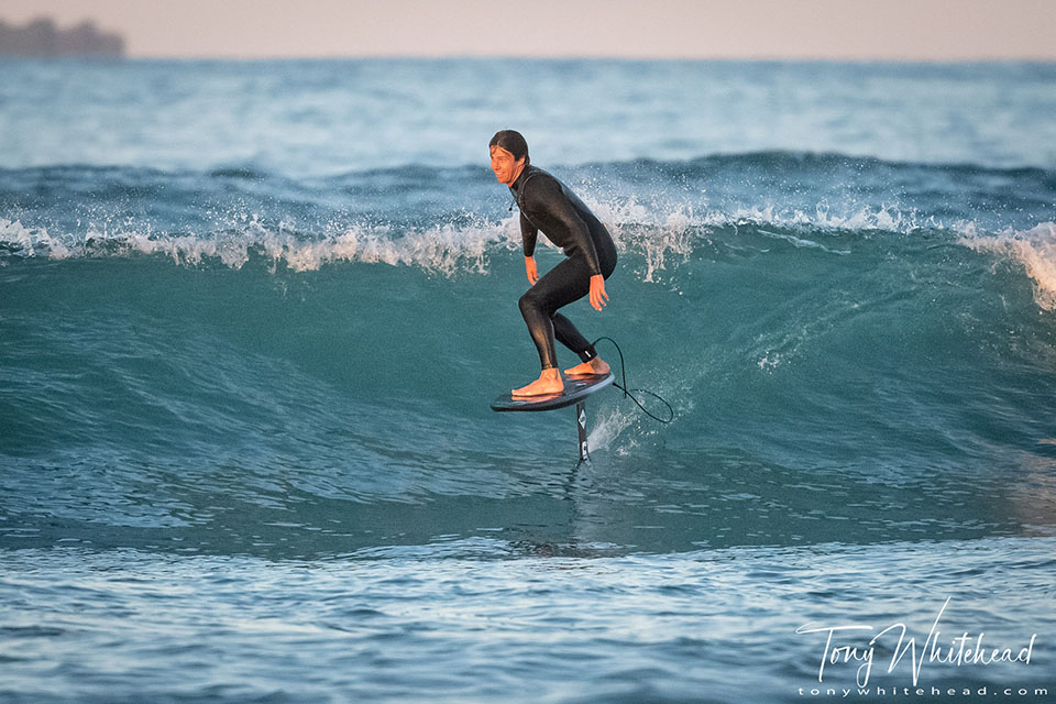 photo of a hydrofoiling board rider on a wave